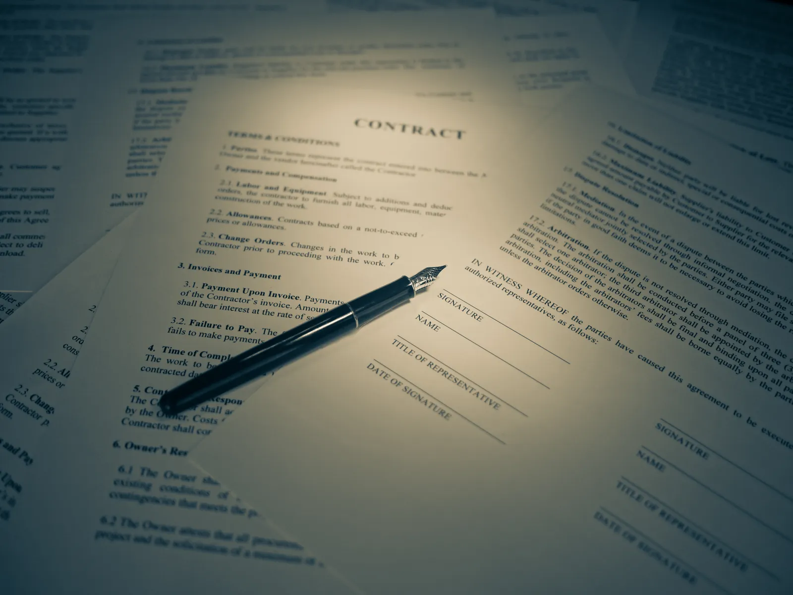 A printed contract with blank signature, name and date lines and a fountain pen