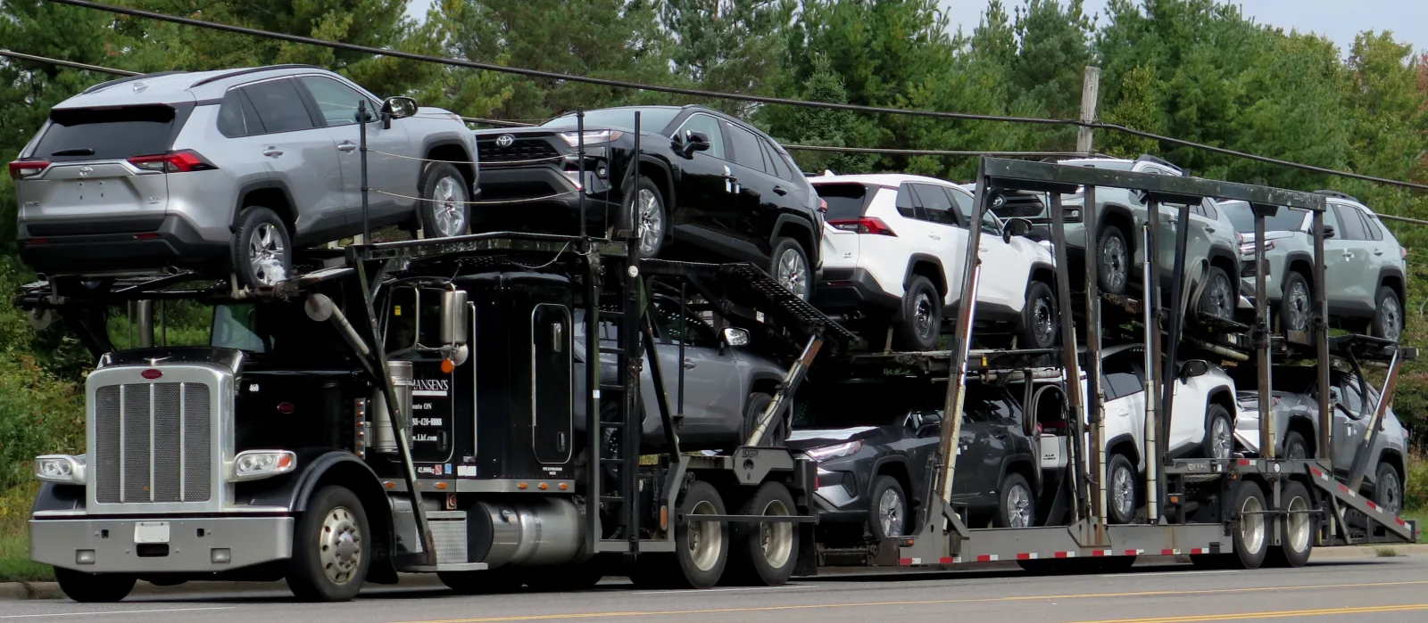 Car hauler truck loaded with new Toyota RAV4 SUVs on a road