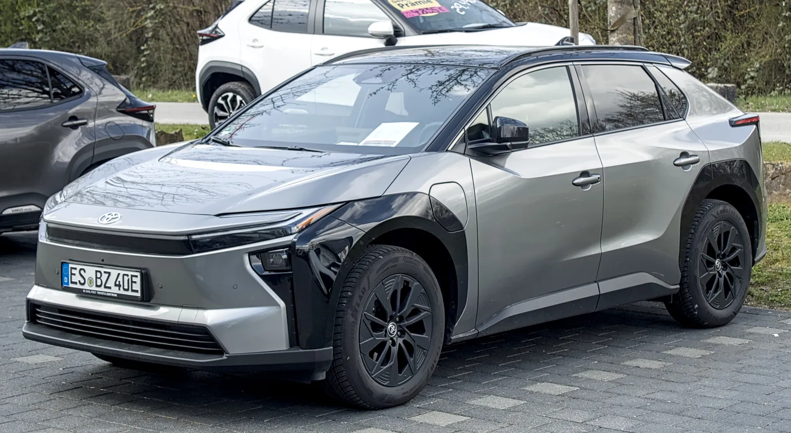 Toyota bZ prata com rodas aro 18 estacionado no pátio de uma concessionária