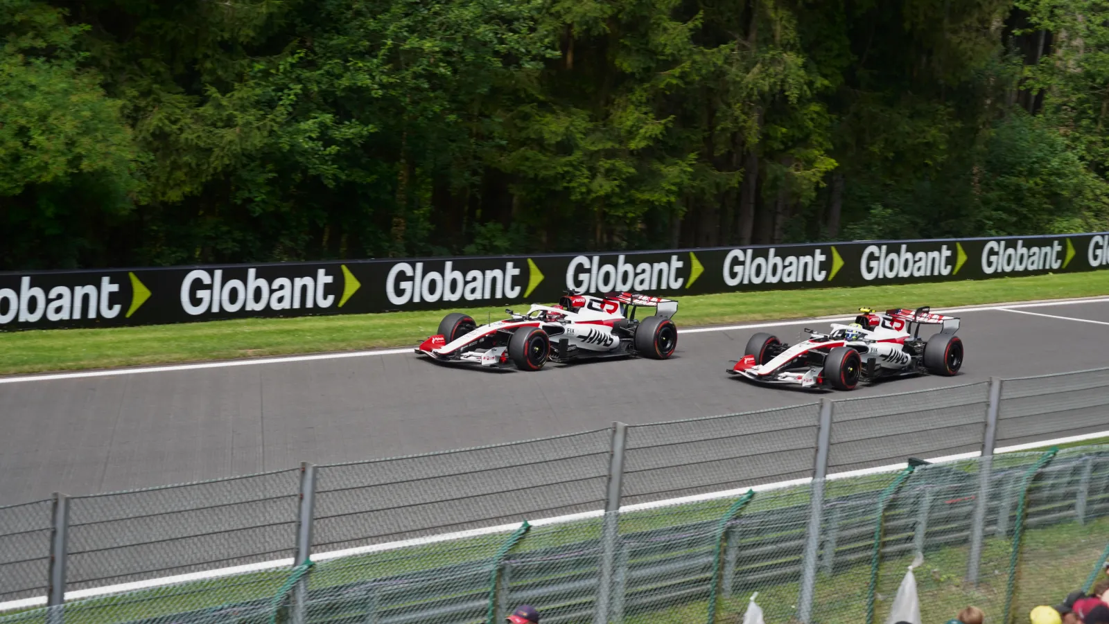 Two Haas VF-26 cars racing close at Spa under manual override mode in F1 2026
